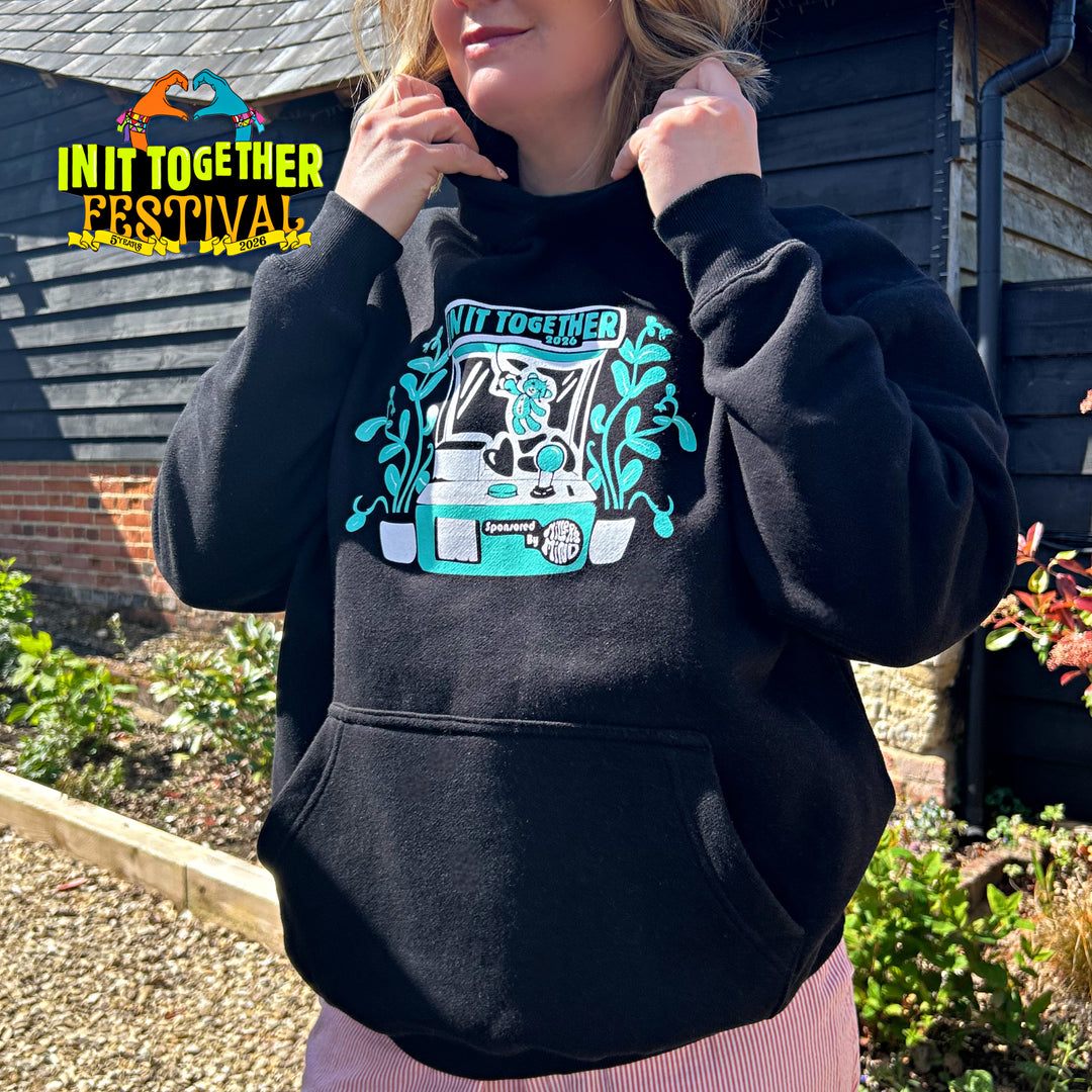 Person wearing a black hoodie with a graphic design, standing outdoors.