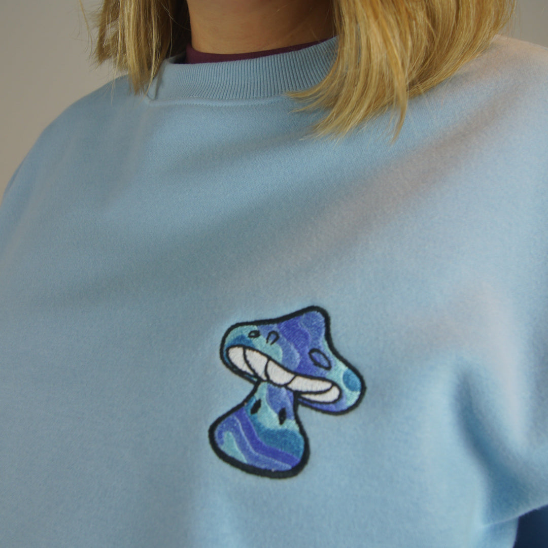 Light blue shirt with a colorful bow design on the back, worn by a person.
