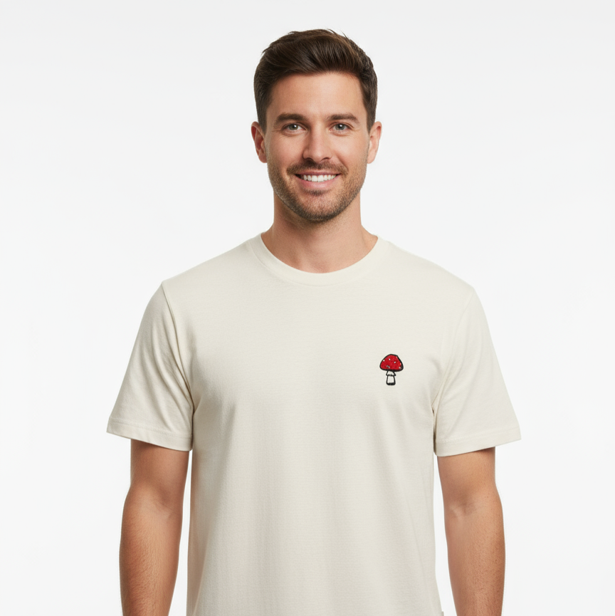 Man wearing a beige t-shirt with a small graphic on a white background