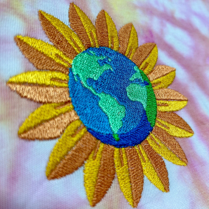Sunny World Embroidery Close-up on pink and yellow T-shirt