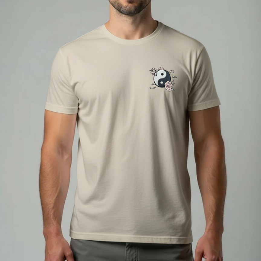Man wearing a beige t-shirt with a logo on a gray background